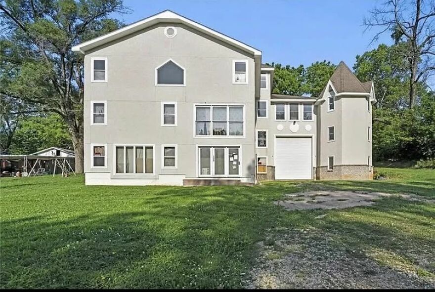 A bizarrely structured house with mismatched windows and a garage, criticized for its architecture design flaws.