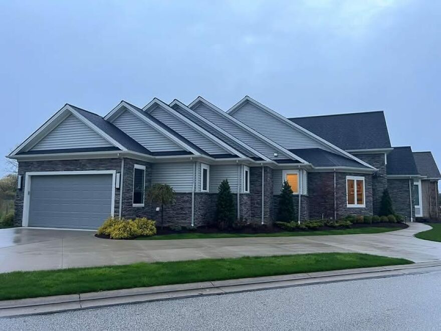 Unusual house design with multiple gabled roofs viewed from the street, showcasing architecture shaming appeal.