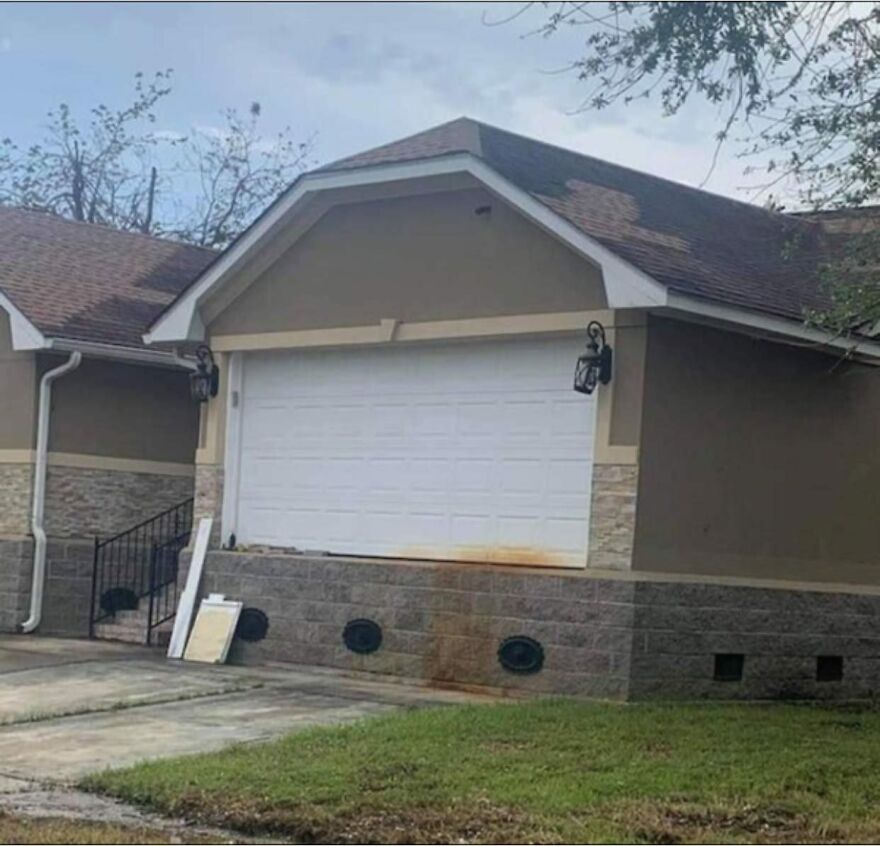 Awful architecture: A garage door installed with no driveway access, highlighting poor building design.