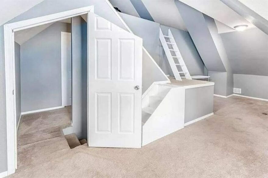 Unusual architectural design with awkward door placement and steep stairs in a gray room.