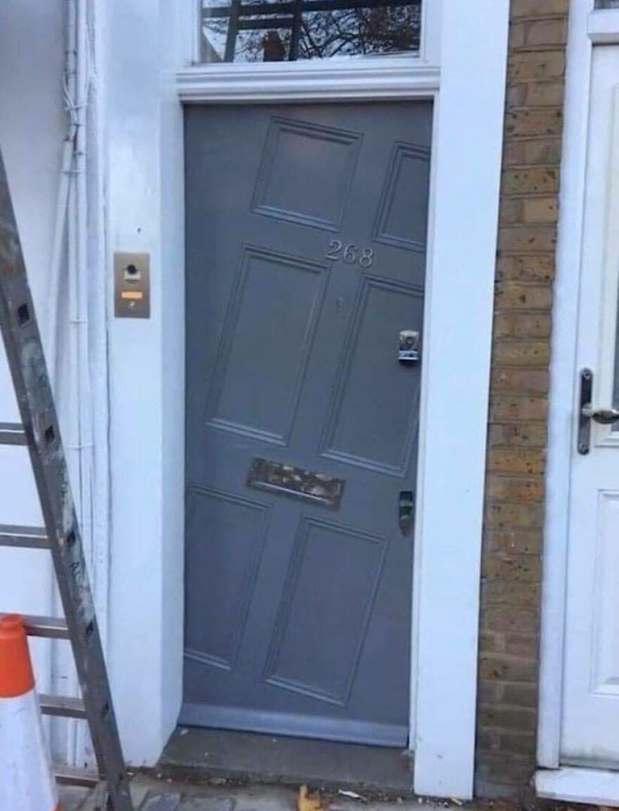 Crookedly installed door on a building, showcasing architecture shaming-worthy design flaw.