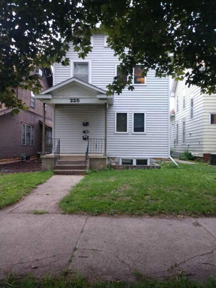 Simple white house with off-center front door, showcasing awkward architecture design.