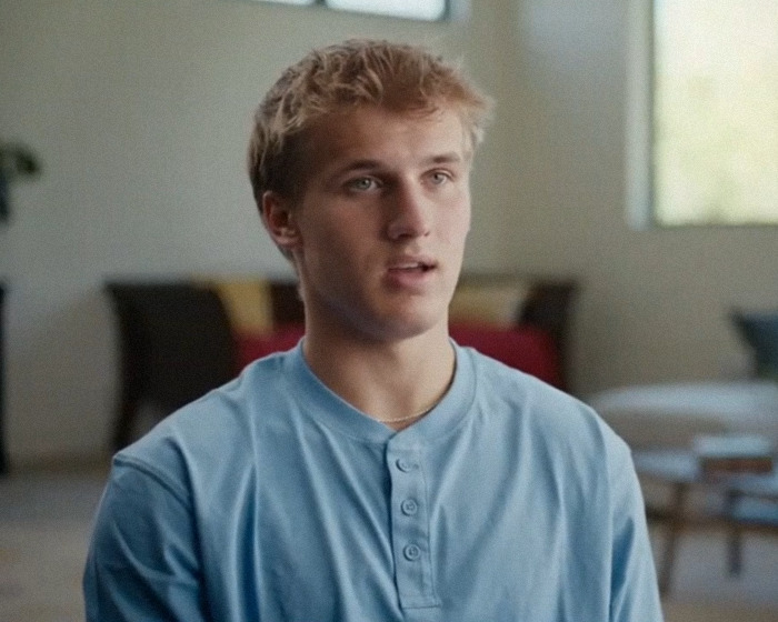 Man in a light blue shirt speaks in an interview setting; related to momfluencer abuse docuseries.