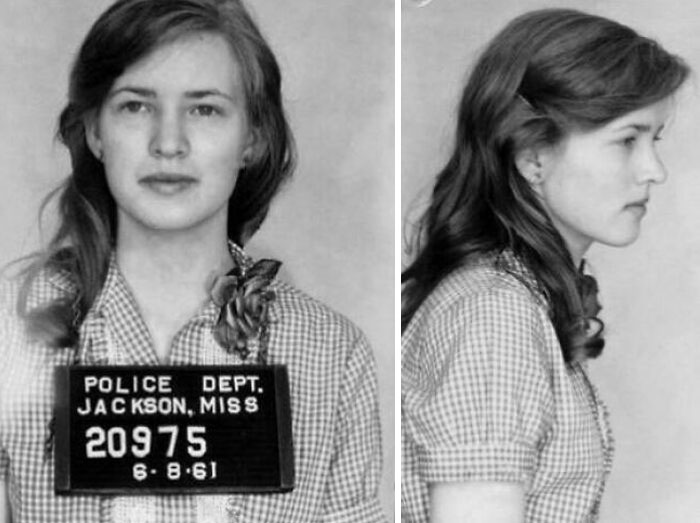 A woman in a 1961 police mugshot, wearing a checkered shirt, showcasing interesting historical facts.