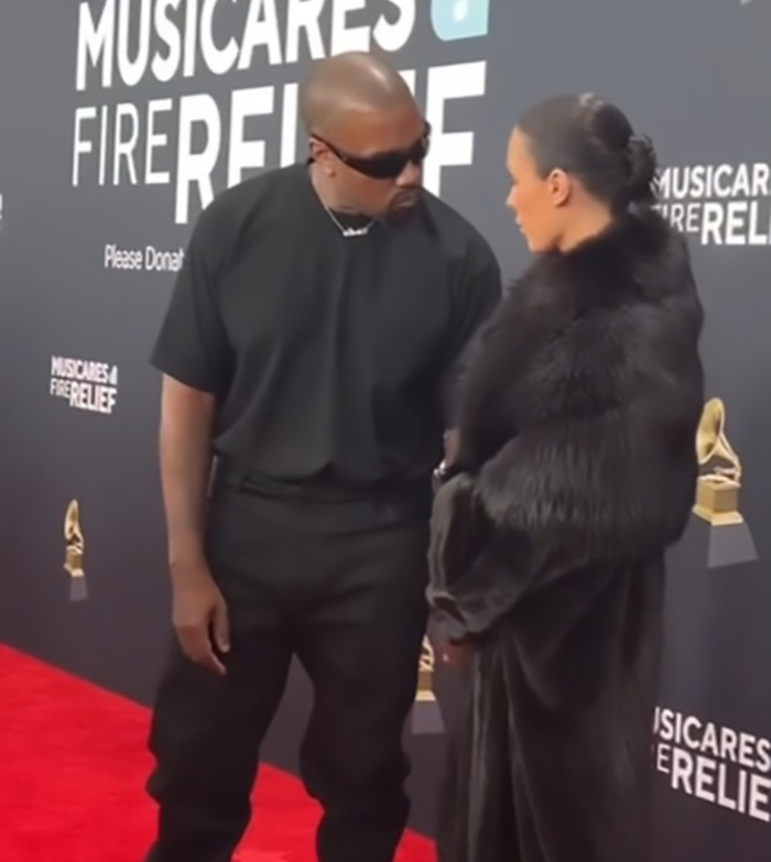 Two people dressed for the red carpet at a music event, engaged in conversation.