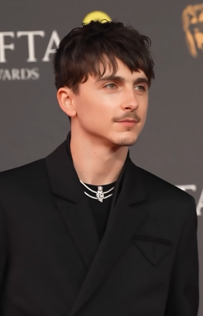 Timothée Chalamet at BAFTA 2025 in a black suit, sparking mixed reactions.