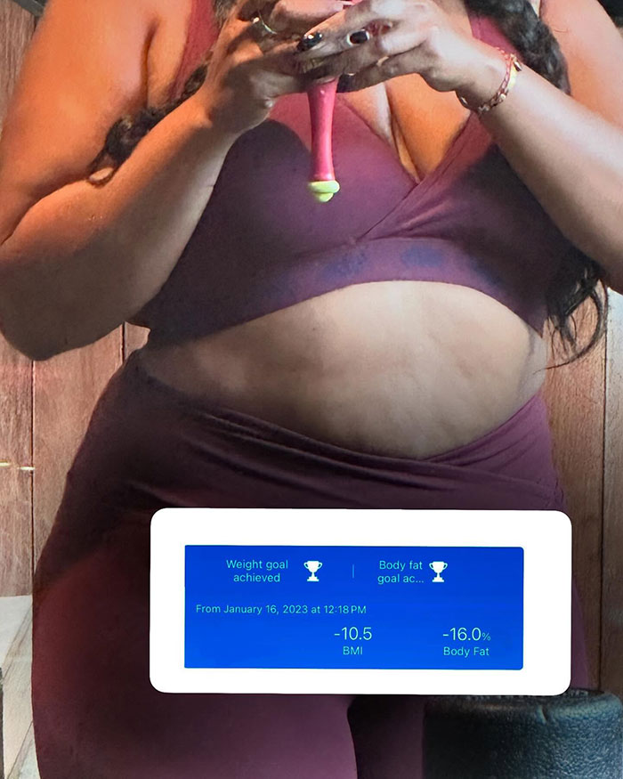 Person in a maroon workout outfit holding a scale, displaying weight loss results with BMI and body fat reduction percentages.