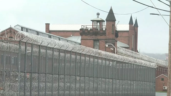 Prison exterior with barbed wire fences, relating to Luigi Mangione's public statement reaction.