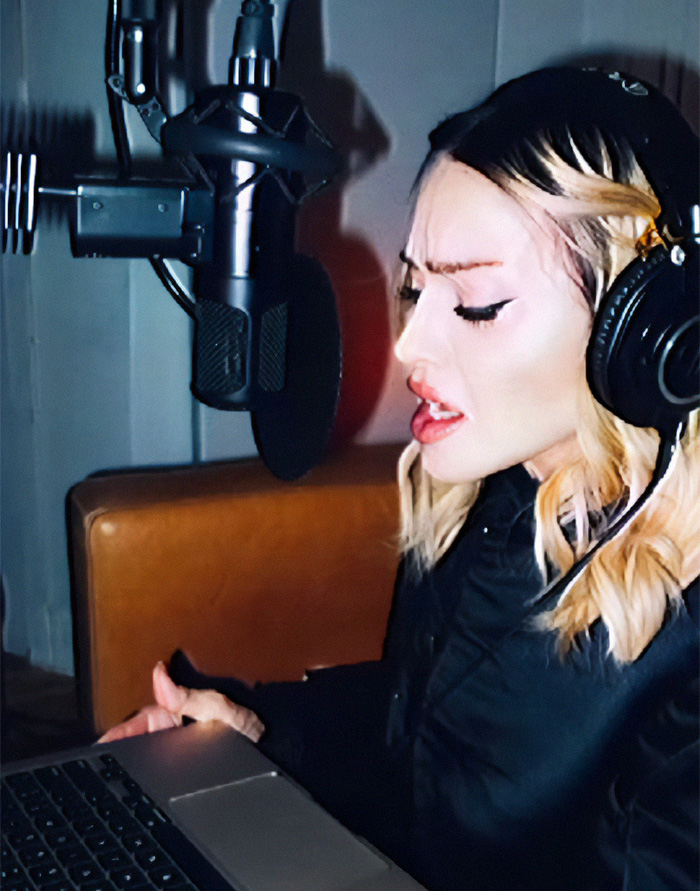 Person recording in a studio with headphones and a microphone