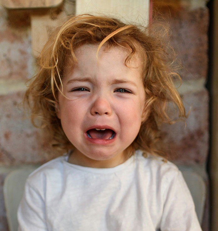 Crying child with messy hair, highlighting store safety concerns.