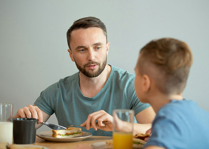 Parenting coach talking calmly to a child over lunch, highlighting reasons to avoid yelling.