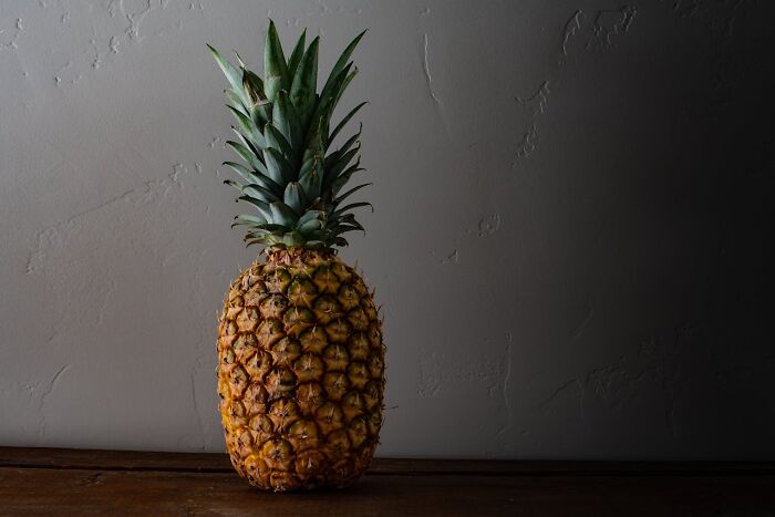 Pineapple on a wooden surface, offering a fresh perspective on tropical fruit.