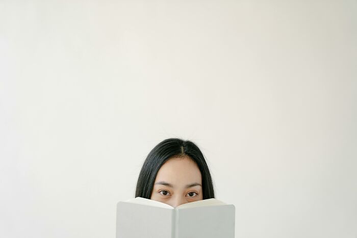 Person reading a book, partially hidden, representing childfree lifestyle choices.