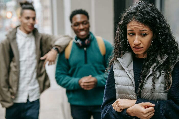 Two people chatting, while another person looks uncomfortable and avoids eye contact, highlighting social aspects of being childfree.