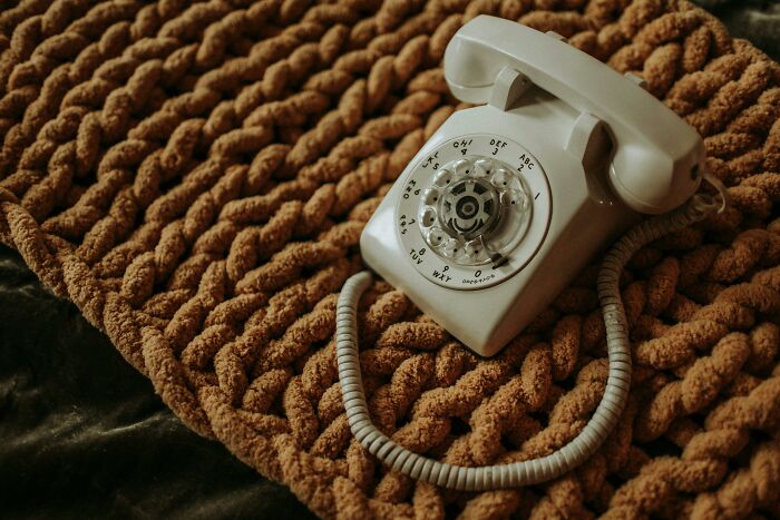 Retro rotary phone on textured brown mat, representing future predictions aged bad.