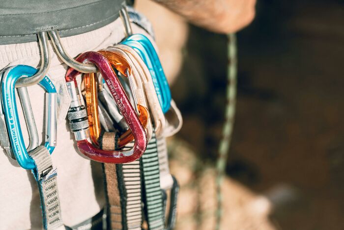 Carabiner set clipped to a belt, showcasing travel must-haves for outdoor adventures.