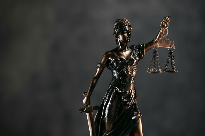 Bronze statue of Lady Justice holding scales and a sword, symbolizing balance and fairness.