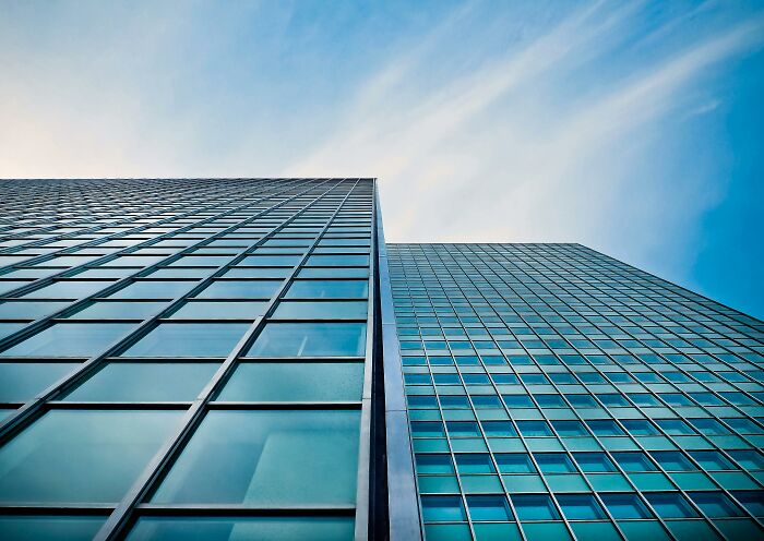 Modern skyscrapers viewed from below against a blue sky, symbolizing mic-drop-moments in urban architecture.