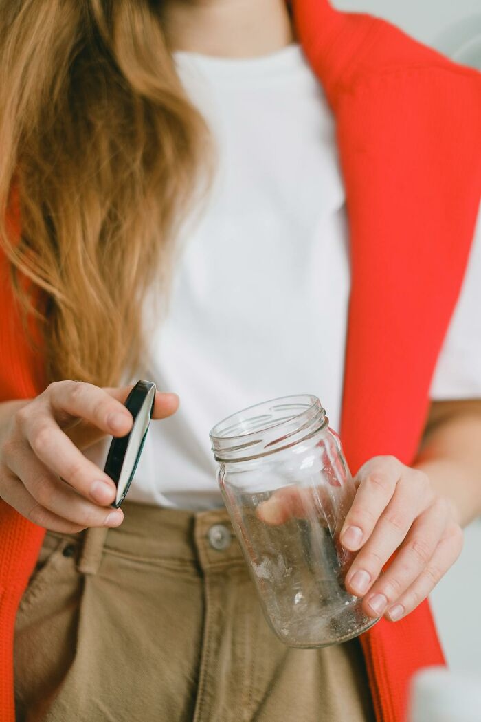 Person holding a mason jar with lid, featuring random facts perspective.