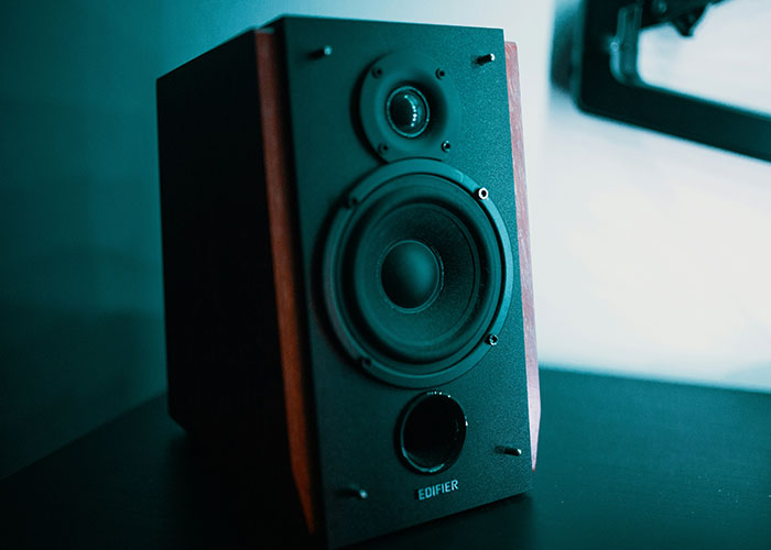 Speaker placed on a table, photographed in soft lighting, illustrating a serene ambiance in an office setting.