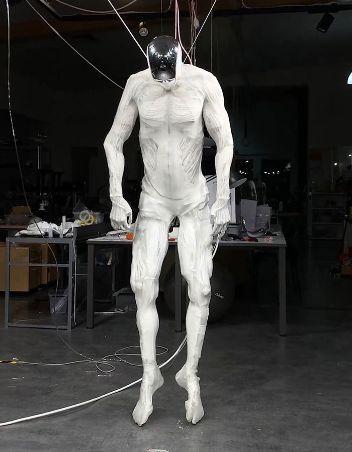 Lifelike humanoid robot with realistic muscles in a laboratory setting.