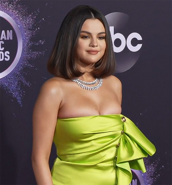 Selena Gomez in a neon green dress at the awards show, showcasing a dramatic weight loss transformation.