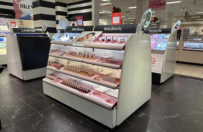 Sephora product display featuring brands like Rare Beauty and Laneige in a well-lit cosmetic store aisle.