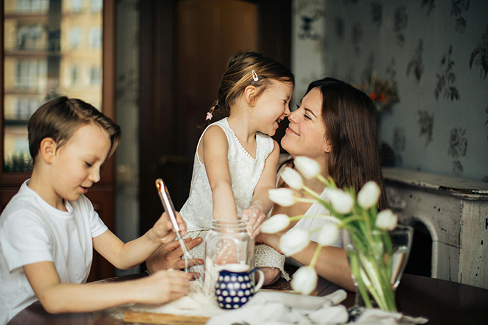 A mother and her two children enjoy baking together, capturing a joyful moment of family bonding.