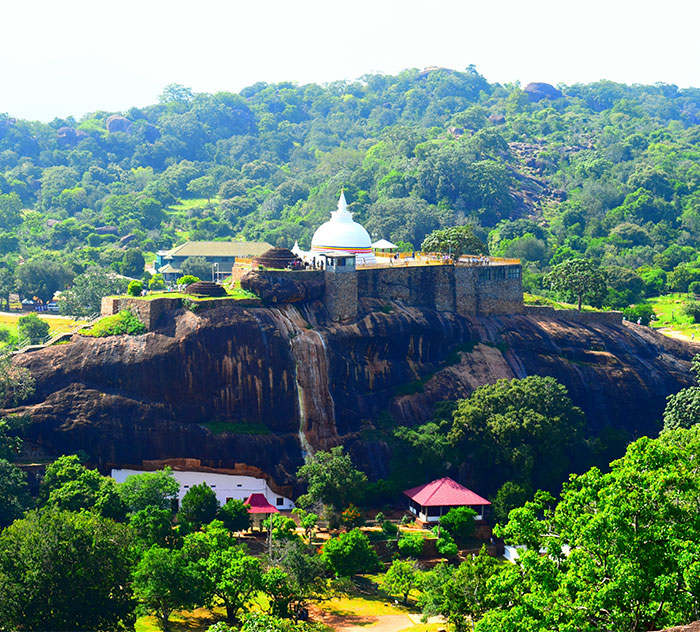 South Asian temple on a rocky hill surrounded by lush greenery, related to influencer's trip.