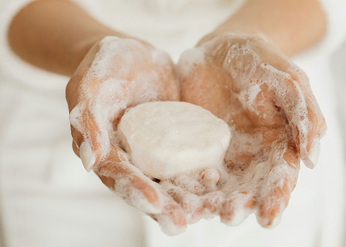 Hands holding a soap bar with bubbles, representing a strange punishment story.