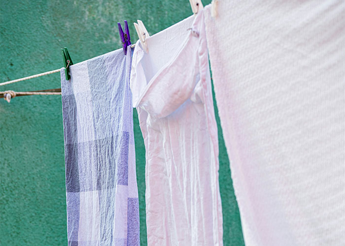 Laundry hanging on a clothesline outdoors, showcasing colorful clothes pegs and a sunny day.