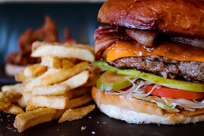 Close-up of a burger and fries, highlighting normalized corporate propaganda in food choices.