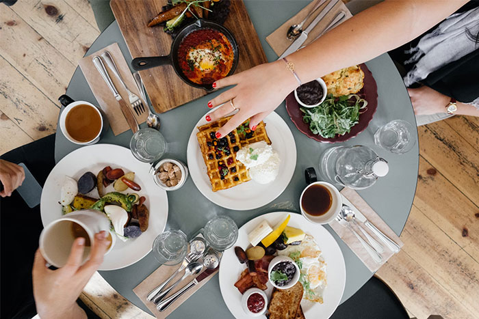 Assorted brunch dishes on a round table, highlighting corporate propaganda's influence on dining habits.