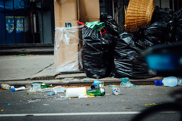 Street littering and garbage bags, showcasing issues normalized by corporate propaganda.