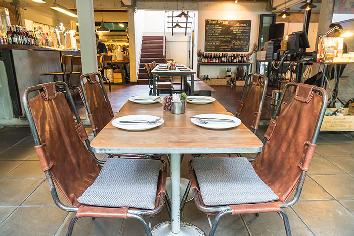 Empty restaurant table setting with leather chairs, highlighting a possible sign of a bad restaurant experience.