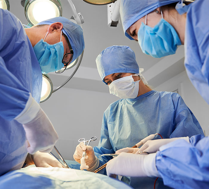 Surgeons in blue scrubs performing a procedure, highlighting women\'s experiences with designer genitals.