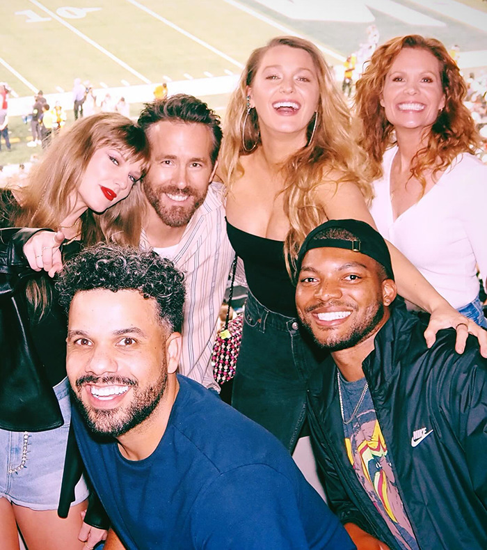 Group of friends smiling at a stadium, capturing a joyful moment in a lively atmosphere.