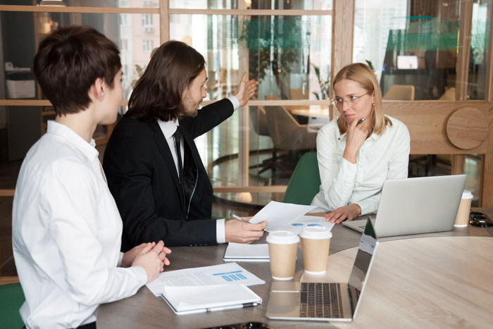 Business team discussing company's structure with a boss in an office meeting.