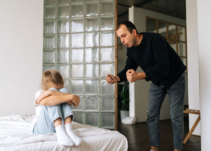 Man arguing with a woman sitting on a bed, highlighting relationship misunderstandings.