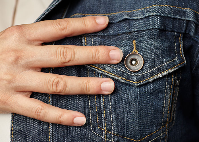 Hand on a denim jacket pocket, highlighting men's discoveries about women after getting a girlfriend.