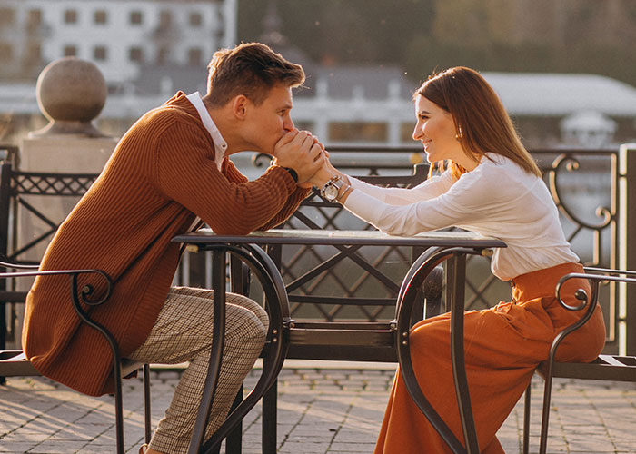 A couple sharing a romantic moment at a table outdoors, highlighting relationship insights from men.