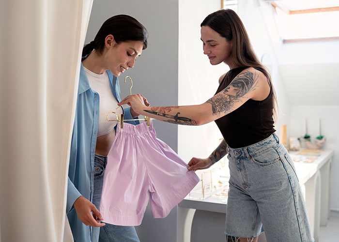 Two women discussing lavender shorts in a boutique, part of relationship insights theme.