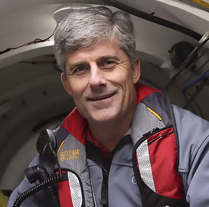 Person inside a submarine, wearing a grey and red jacket, related to Titan Sub's last moments.