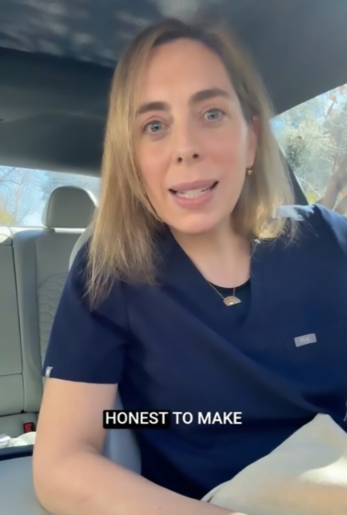 Surgeon in car discussing a legal letter from UnitedHealthcare, wearing blue medical scrubs.