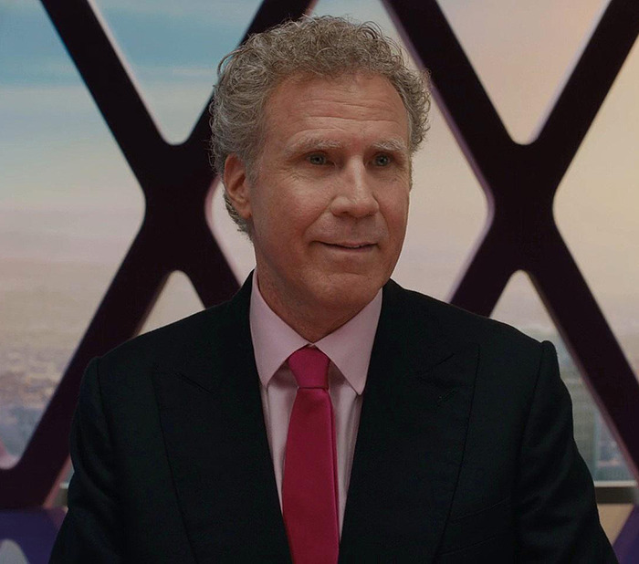 Man in suit and pink tie smiling, related to humorous dance trend.