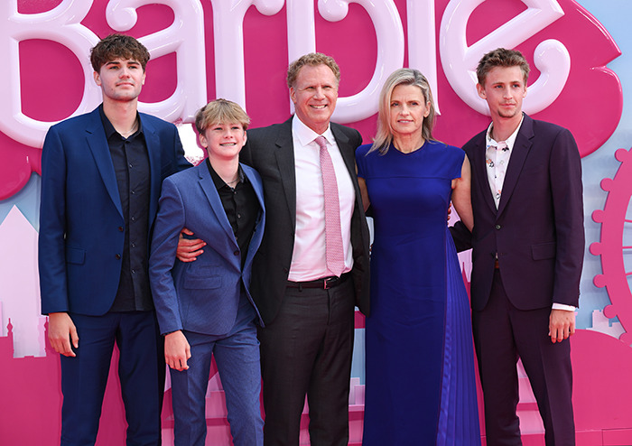 Family in formal attire at a pink-themed event, smiling for the camera.