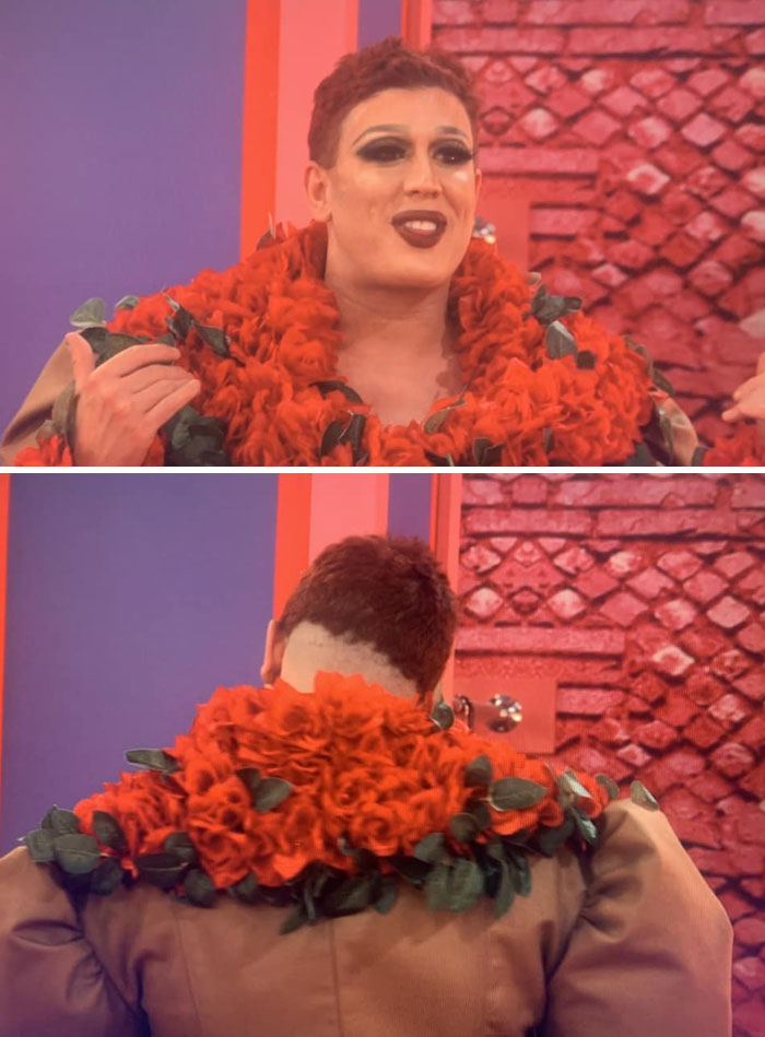 Person with an unusual hair fail in a flamboyant red floral outfit, posing in a colorful indoor setting.