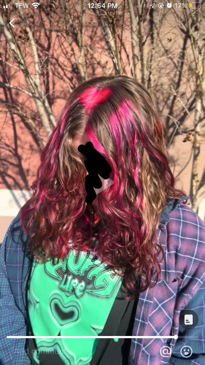 Woman with pink streaked hair outside, showcasing a vivid hair fail.