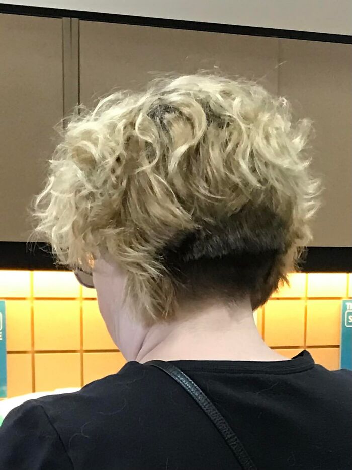 Curly blonde hair with an unevenly cut underlayer, showcasing a hair fail.