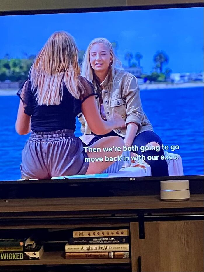 Two women sitting by the water, discussing a decision, with one facing the camera. Hair fails mentioned in context.